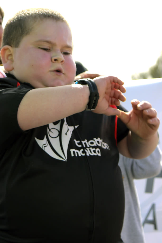 Jake checks his watch during a triathlon in Malta (Picture: Caters)