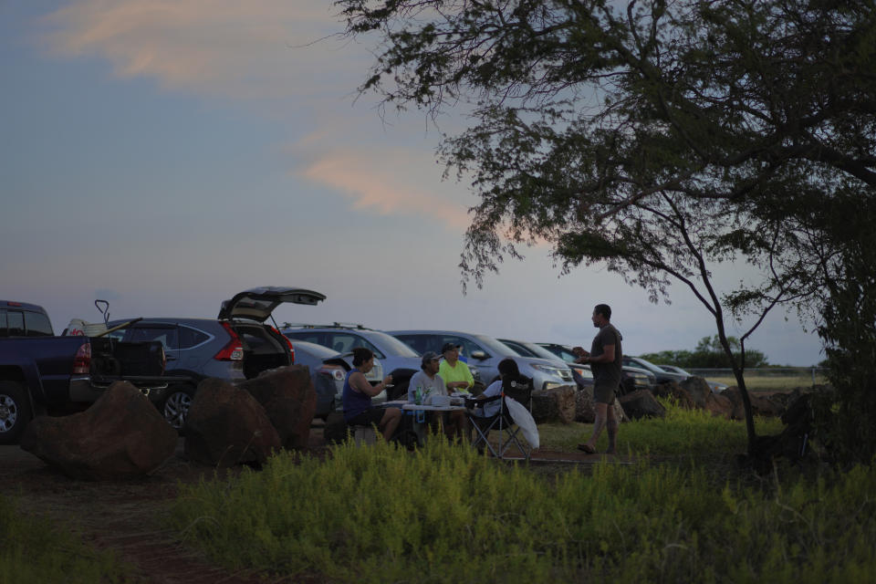 Salt makers gather for a meal after working in the Hanapepe salt patch on Sunday, July 9, 2023, in Hanapepe, Hawaii. 22 Native Hawaiian families work the beds each summer to make "paakai," or Hawaiian salt, which can only be given away or traded, never sold. (AP Photo/Jessie Wardarski)