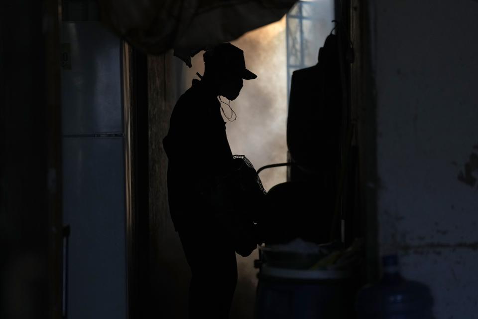 Un trabajador de salud fumiga contra los mosquitos para ayudar a mitigar la propagación del dengue en una casa en el barrio marginal La Primavera en Piura, Perú, el sábado 3 de junio de 2023. (AP Foto/Martín Mejía)