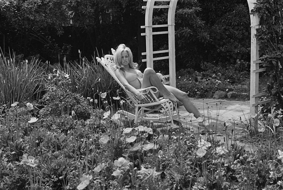 <p>Farrah Fawcett sun bathes in a garden in May of 1970.</p>