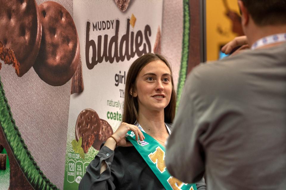 Taylor Busser, left, talks with co-worker John Wotczak, both with General Mills, while showing the General Mills partnership with Girl Scouts cookies, during The Sweet & Snacks Expo, Tuesday, May 14, 2024 at the Indiana Convention Center. They displayed the Muddy Buddies Girl Scouts Thin Mints snack.