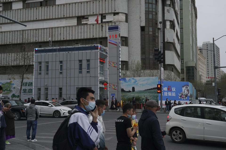 Pedestrians walk past a police station in Urumqi, the capital of China's far west Xinjiang region, on April 21, 2021. Four years after Beijing's brutal crackdown on largely Muslim minorities native to Xinjiang, Chinese authorities are dialing back the region's high-tech police state and stepping up tourism. But even as a sense of normality returns, fear remains, hidden but pervasive. (AP Photo/Dake Kang)