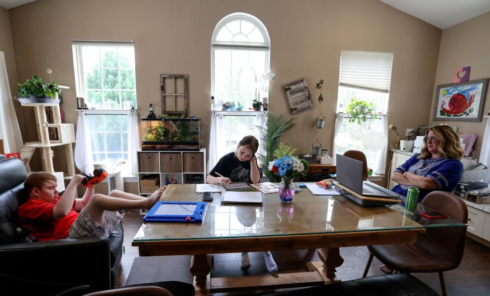 Glenn Maughan, nicknamed Bug, spins the wheels of a toy truck over and over again as his sister Taylor Maughan and mother mother Annette Maughan work on a children’s book they are writing and illustrating about being different, at their home in Manchester, Md., on Friday, July 7, 2023. Bug, the inspiration for the book, has KBG syndrome. | Kristin Murphy, Deseret News