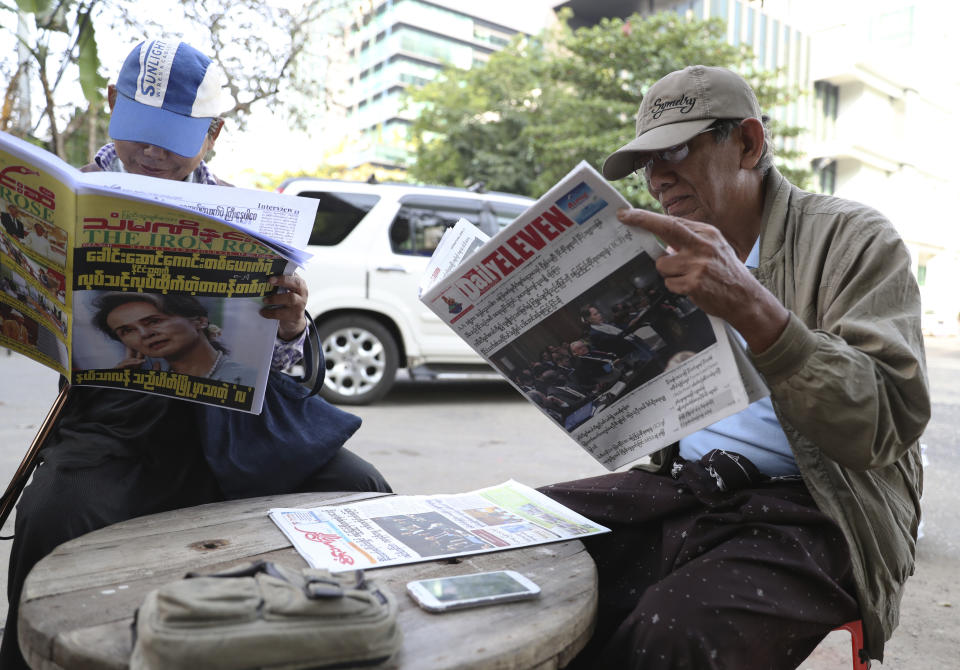 Locals read through newspapers with fronts leading with Myanmar leader Aung San Suu Kyi at the International Court of Justice hearing outside a roadside shop Thursday, Dec. 12, 2019, in Yangon, Myanmar. Suu Kyi testified to the court that the exodus of hundreds of thousands of Rohingya Muslims to neighboring Bangladesh was the unfortunate result of a battle with insurgents. She denied that the army had killed civilians, raped women and torched houses. (AP Photo/Thein Zaw)