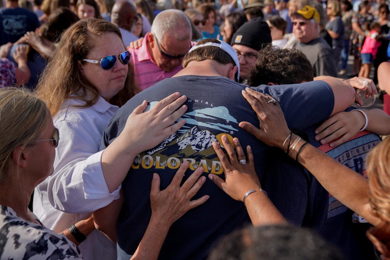 Community members embrace each other during a vigil the day after a shooting during a teenager’s birthday party (Reuters)