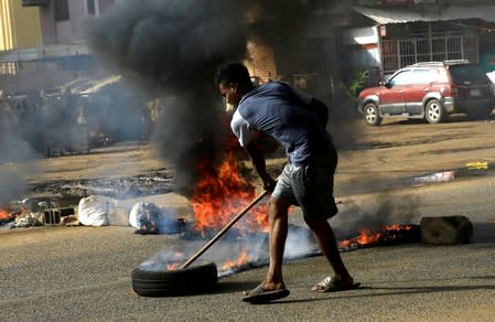 A Sudanese protester uses a tyre to erect a barricade on a street and demanding that the country's Transitional Military Council hand over power to civilians in Khartoum