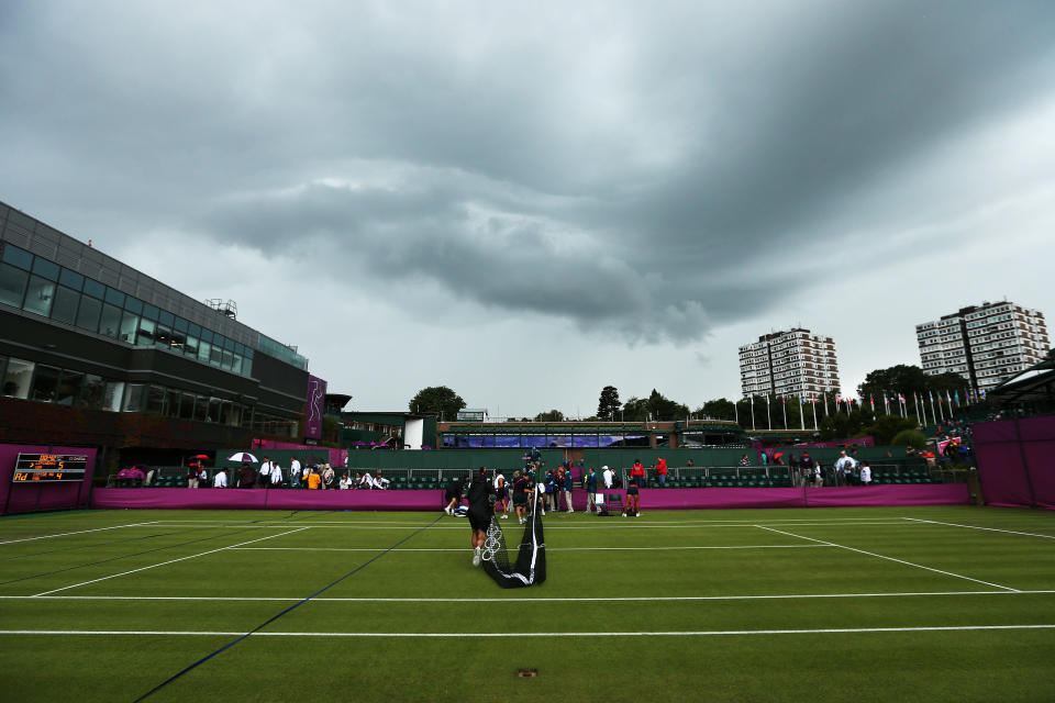 LONDON, ENGLAND - JULY 29: Members of the groundstaff remove the net on a court as rain delays play on Day 2 of the London 2012 Olympic Games at the All England Lawn Tennis and Croquet Club in Wimbledon on July 29, 2012 in London, England. (Photo by Ezra Shaw/Getty Images)