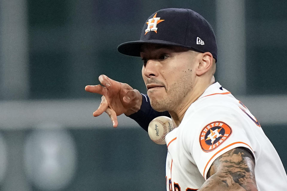 Houston Astros shortstop Carlos Correa loses the ball while fielding a single by Texas Rangers' Willie Calhoun during the sixth inning of a baseball game Tuesday, June 15, 2021, in Houston. (AP Photo/David J. Phillip)