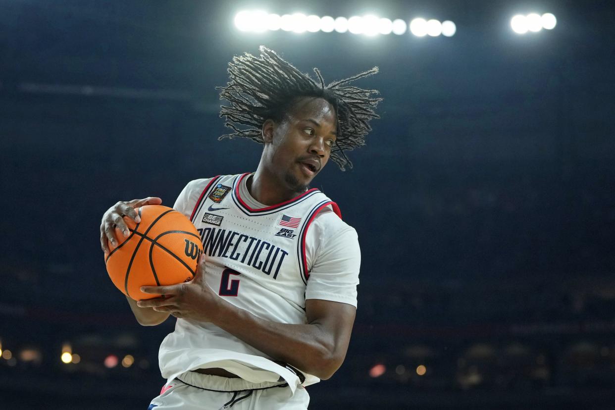 Apr 6, 2024; Glendale, AZ, USA; Connecticut Huskies guard Tristen Newton (2) grabs the ball against the Alabama Crimson Tide during the second half in the semifinals of the men's Final Four of the 2024 NCAA Tournament at State Farm Stadium. Mandatory Credit: Bob Donnan-USA TODAY Sports