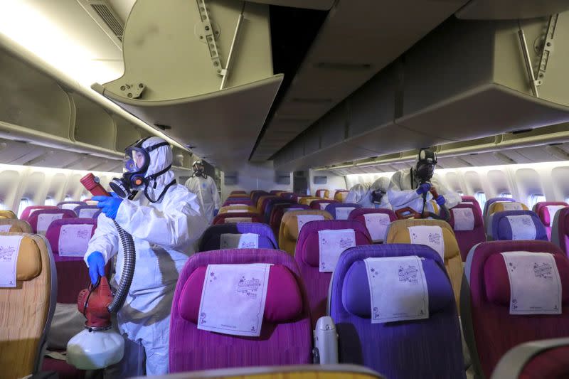 FILE PHOTO: Members of the Thai Airways crew disinfect the cabin of an aircraft of the national carrier during a procedure to prevent the spread of the coronavirus at Bangkok's Suvarnabhumi International Airport