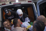 Ramallah governor Laila Ghannam, with a white scarf, carries the body of 2 1/2 year old Palestinian toddler Mohammed al-Tamimi out of an ambulance, upon his arrival at the Palestine Medical Complex, the West Bank city of Ramallah, Monday, June 5, 2023. The Palestinian toddler who was shot by Israeli troops in the occupied West Bank last week died of his wounds on Monday, Israeli hospital officials said. (AP Photo/Nasser Nasser)