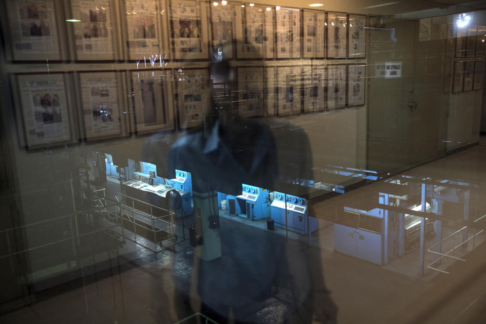 A journalist is reflected in a window at Panorama newspaper in Maracaibo, Venezuela, May 16, 2019. Panorama, which was established in 1914, published a"See you Soon" headline to announce its last print edition, due to lack of newsprint. (AP Photo/Rodrigo Abd)