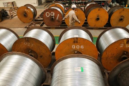 FILE PHOTO: A worker walks past rolls of steel wires at a factory in Nantong, Jiangsu province, China July 3, 2018. REUTERS/Stringer/File Photo