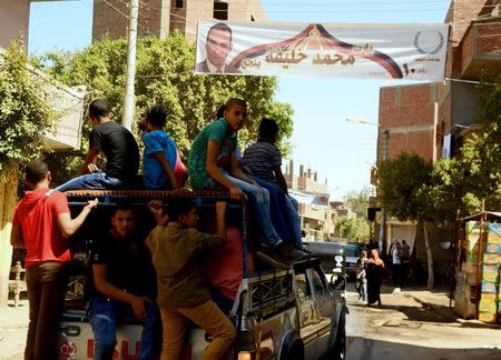 People travel to work as a election banner for parliamentary candidate Mohamed Khalifa is seen in Minya governorate, south of Cairo, Egypt, October 8, 2015. REUTERS/Stringer