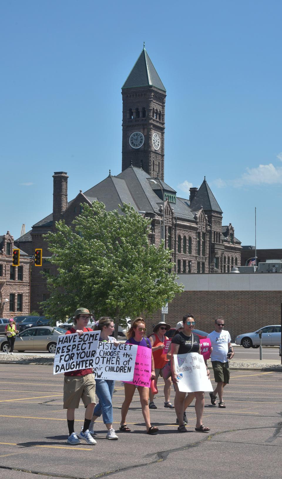 People walk in front of the Old Courthouse Museum on their way to Van Epps Park for an abortion rights rally on Sunday, July 10, 2022.