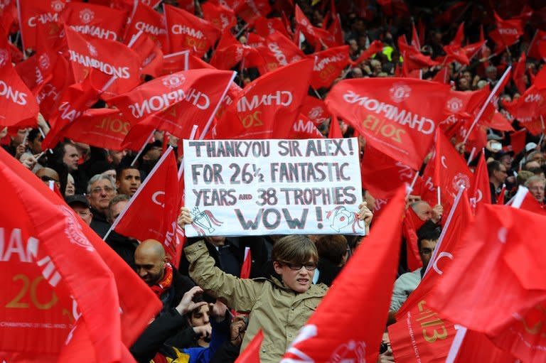 A supporter holds a banner showing support for Manchester United's Scottish manager Alex Ferguson in a sea of red flags during the English Premier League football match between Manchester United and Swansea City at Old Trafford in Manchester, northwest England, on May 12, 2013. United won 2-1