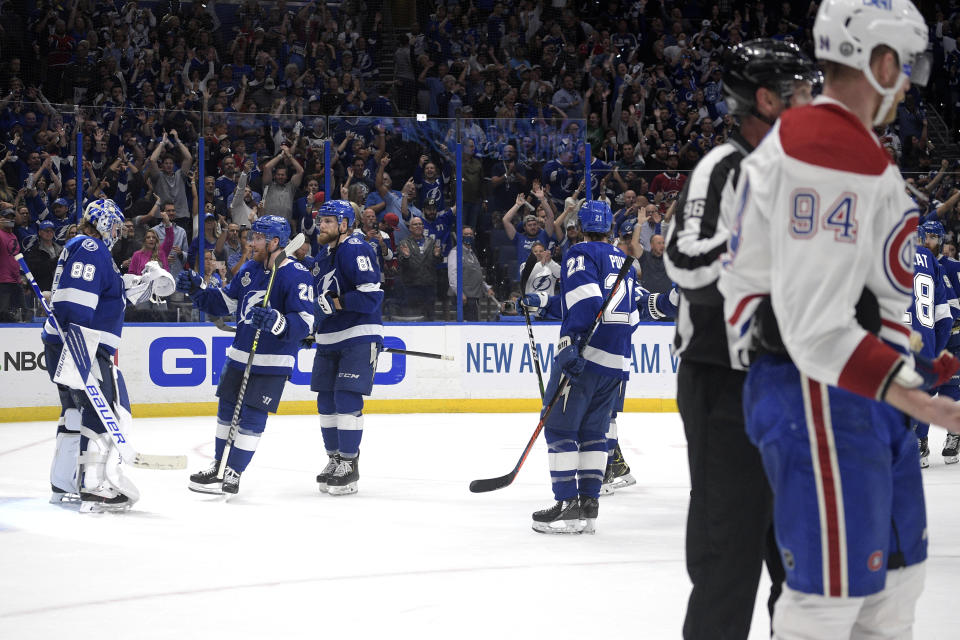 Montreal Canadiens right wing Corey Perry (94) skates off the ice as Tampa Bay Lightning goaltender Andrei Vasilevskiy is greeted by teammates after the third period in Game 2 of the NHL hockey Stanley Cup finals, Wednesday, June 30, 2021, in Tampa, Fla. The Lightning won 3-1. (AP Photo/Phelan Ebenhack)