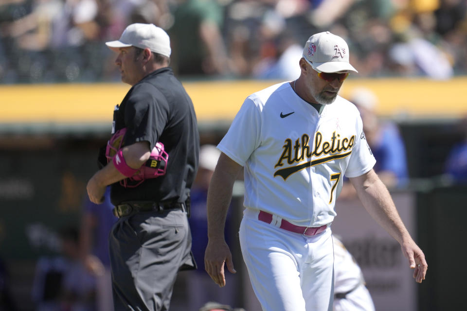 Oakland Athletics manager Mark Kotsay (7) walks toward the dugout after being ejected by umpire Dan Bellino, left, during the eighth inning of the team's baseball game against the Texas Rangers in Oakland, Calif., Sunday, May 14, 2023. (AP Photo/Jeff Chiu)