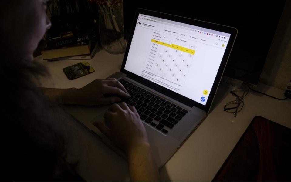 A woman checks the schedule for planned power cuts in her area on energy company DTEKs website  - Ed Ram/Getty Images Europe