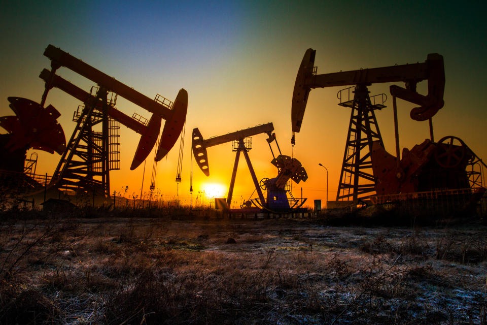 Pumps in an oil field at sunset