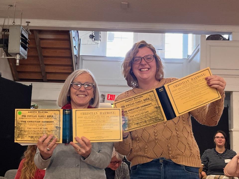 Mars Hill University's Darian Smathers and her relative, June Smathers Jolley, show off their copies of Zack Allen's latest reprint of Christian Harmony, a shape note singing hymnal book.