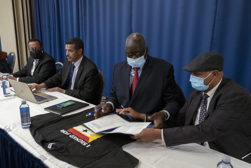 Okok Ojulu Okok, second right receives documents during signing ceremony of the United Front of Ethiopian Federalist and Confederalist Forces to establish a grand United Front to fight against the Abiy Ahmed regime in Ethiopia, in Washington, Friday, Nov. 5, 2021. Ethiopia’s Tigray forces on Friday joined with other armed and opposition groups around the country in an alliance against Prime Minister Abiy Ahmed to seek a political transition after a year of devastating war, and they left the possibility open for his exit by force. (AP Photo/Gemunu Amarasinghe)
