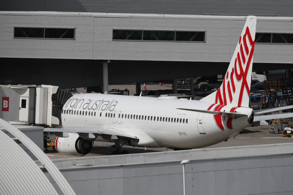 A Virgin Australia Airlines plane is seen at Kingsford Smith International Airport the morning after Australia implemented an entry ban on non-citizens and non-residents intended to curb the spread of the coronavirus disease (COVID-19) in Sydney, Australia, March 21, 2020.  REUTERS/Loren Elliott