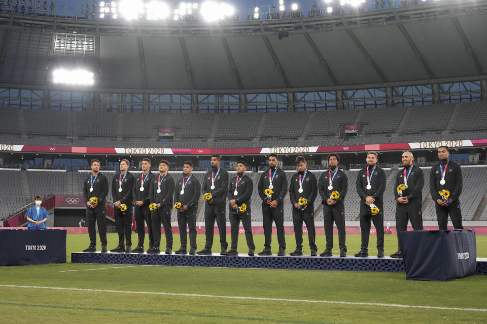 New Zealand players pose on the podium with their silver medals in men's rugby sevens at the 2020 Summer Olympics, Wednesday, July 28, 2021 in Tokyo, Japan. (AP Photo/Shuji Kajiyama)