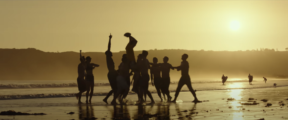 A group of men playing football on the beach