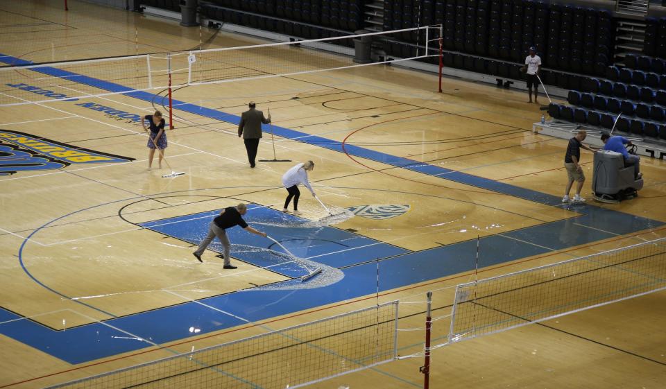 Workers try to clear water from the floor of Pauley Pavillion on the UCLA campus from a broken thirty inch water main, which gushed water onto Sunset Boulevard in the Westwood section of Los Angeles July 29, 2014. The geyser from the 100-year old water main flooded parts of the campus and stranded motorists on surrounding streets. REUTERS/Danny Moloshok