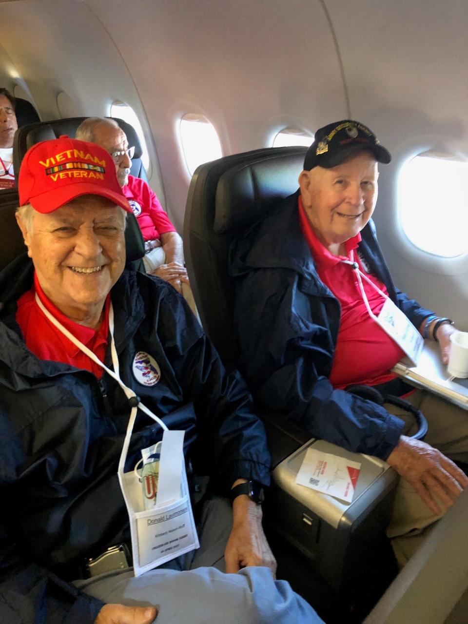 Donald Lavimoniere (left) smiles for a photo with his row-mate aboard the Collier-Lee Honor Flight out of Fort Myers, Fla.