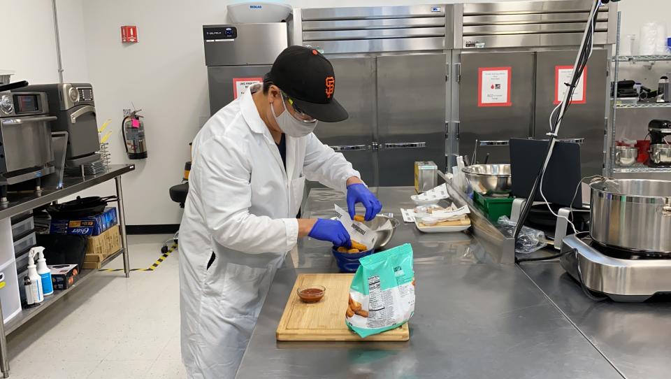 Nathan Foot, R&D chef at Impossible Foods, puts its new meatless nuggets into a serving bowl in the company’s test kitchen on Sept. 21, 2021 in Redwood City, Calif. The plant-based nuggets taste are designed to taste like chicken. (AP Photo/Terry Chea)