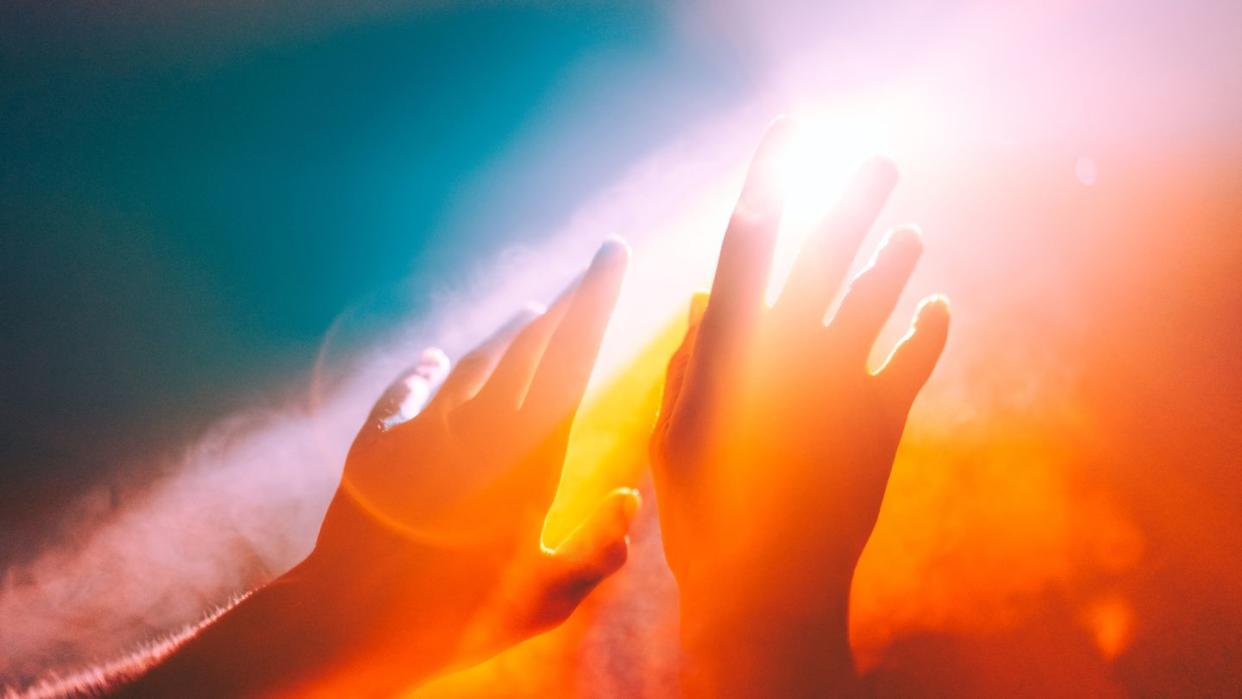 human hands stretched out to the burning sun, ethereal and unreal concepts of universe, spiritual and natural powers