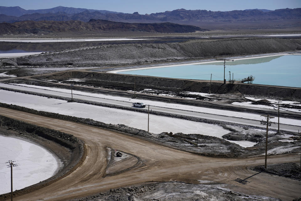 FILE - A truck drives past brine evaporation ponds at Albemarle Corp.'s Silver Peak lithium facility, on Oct. 6, 2022, in Silver Peak, Nev. Threatened by possible shortages of lithium for electric car batteries, automakers are racing to lock in supplies of the once-obscure "white gold" in a politically and environmentally fraught competition from China to Nevada to Chile. (AP Photo/John Locher, File)