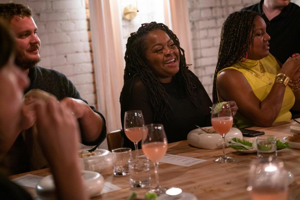 Kiana Wenzell, 42, co-executive of Design Core and director of Detroit Month of Design, center, laughs while talking with guests during Tablescape, a dinner that merges art and food, at Marrow in Detroit on Friday, Sept. 8, 2023.