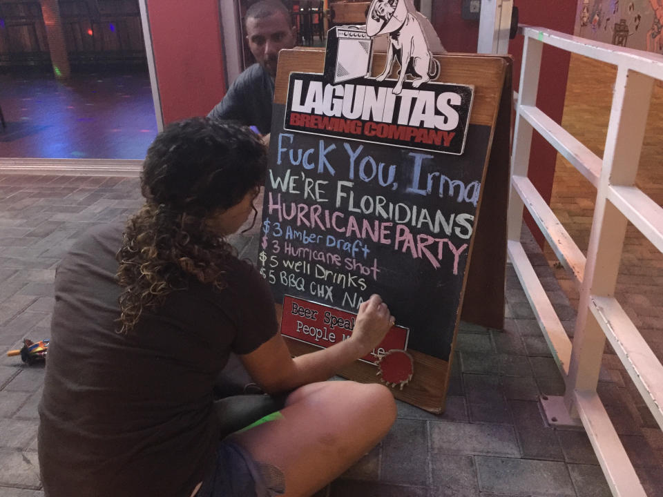 A bar employee in Fort Lauderdale scrawls a sign announcing a Hurricane Irma party. (Photo: Travis Waldron/HuffPost)