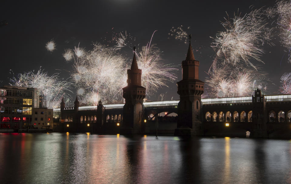 New Year's Eve fireworks light up the night sky at the turn of the year above the Oberbaumbrucke bridge in Berlin, Sunday, Jan. 1, 2023. (Paul Zinken/dpa via AP)