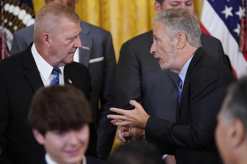 Activist and entertainer Jon Stewart speaks with Jerry Ensminger, Camp LeJeune survivor, after President Joe Biden signed the "PACT Act of 2022" during a ceremony in the East Room of the White House, Wednesday, Aug. 10, 2022, in Washington. (AP Photo/Evan Vucci)