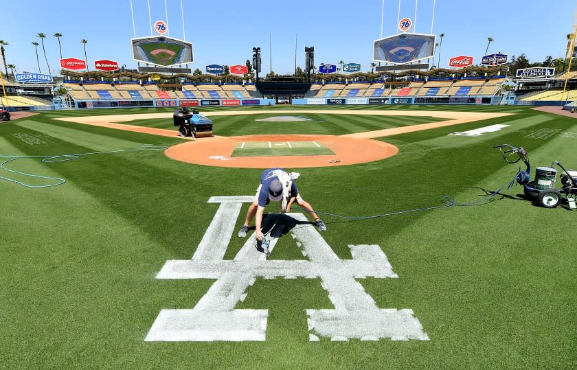 LOS ANGEL;ES, CALIFORNIA APRIL 8, 2021-Dodgers ground crew member Justin Patenaude paints the field.