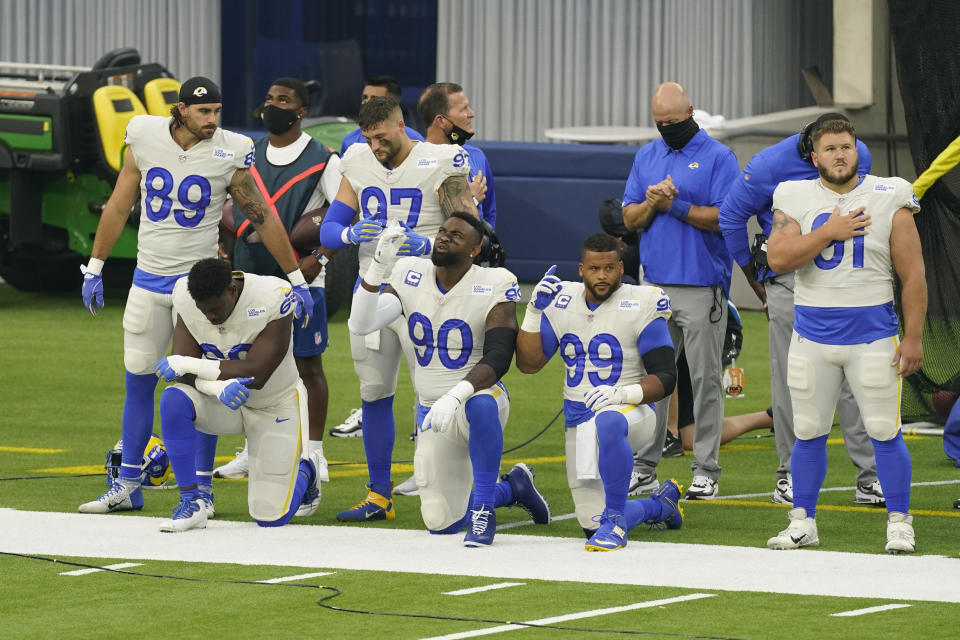 Members of the Los Angeles Rams stand and kneel during the national anthem before an NFL football game against the Dallas Cowboys Sunday, Sept. 13, 2020, in Inglewood, Calif. (AP Photo/Ashley Landis)