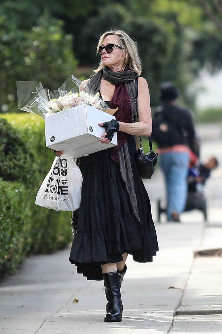 Melanie Griffith fue sorprendida en Beverly Hills cargando flores y una torta. La actriz se dirigía a la casa de una amiga con un look relajado: un vestido largo y holgado, botas y guantes de cuero negro