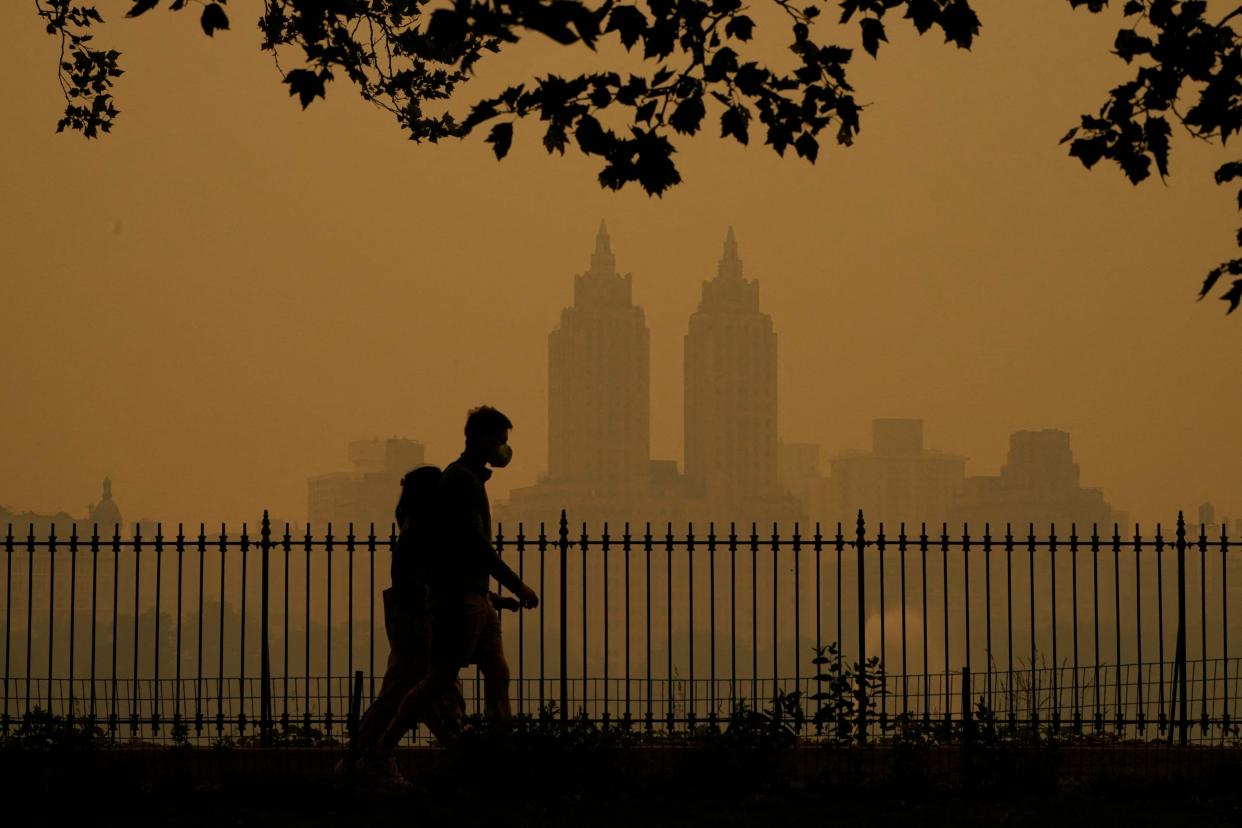 People walk in Central Park as smoke from wildfires in Canada cause hazy conditions in New York City on June 7, 2023. Smoke from Canada's wildfires has engulfed the Northeast and Mid-Atlantic regions of the US, raising concerns over the harms of persistent poor air quality.