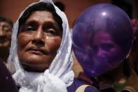 <p>Women, one holding a balloon, attend a procession honoring “The Lord of Miracles,” the patron saint of Lima, in Lima, Peru, Oct. 18, 2012. (Photo: Rodrigo Abd/AP) </p>