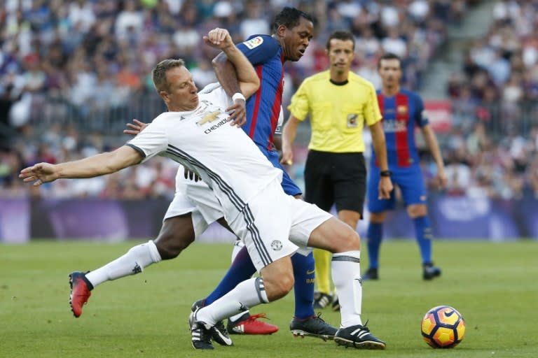 Dutch former Barcelona forward Patrick Kluivert (R) tackles ex-Manchester United defender Lee Martin during a charity match between Barcelona Legends and Man United Legends at the Camp Nou stadium in Barcelona on June 30, 2017