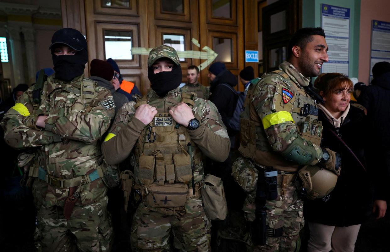Ben grant and other foreign fighters from the UK pose for a picture as they are ready to depart towards the front line in the east of Ukraine following the Russian invasion, at the main train station in Lviv, Ukraine, March 5, 2022. Picture taken March 5, 2022.   REUTERS/Kai Pfaffenbach