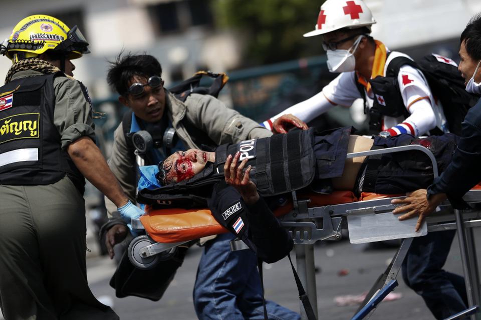 A wounded policeman is transported on a stretcher during clashes with anti-government protesters in Bangkok