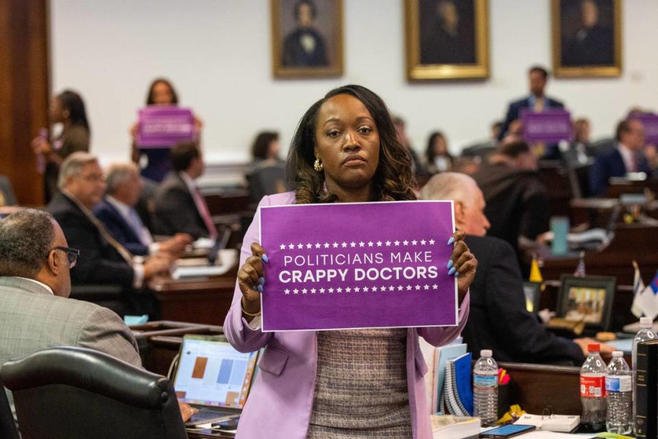 Democratic Senators including Natalie Murdock of Durham County, foreground, hold signs after a vote on an abortion restrictions bill that was up for a veto override on Tuesday, May 16, 2023, at the Legislative Building in Raleigh, N.C.