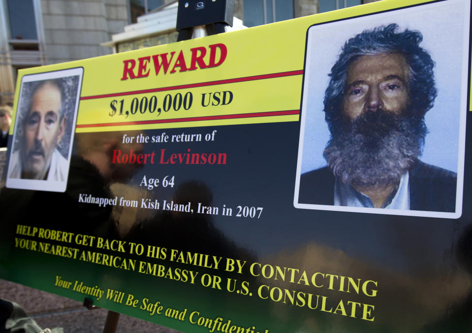 FILE -- In this March 6, 2012 file photo, an FBI poster showing a composite image of former FBI agent Robert Levinson, right, of how he would look like now after five years in captivity, and an image, left, taken from the video, released by his kidnappers, in Washington during a news conference. The family of Levinson, who went missing in Iran a decade ago on an unauthorized CIA assignment, filed a lawsuit Tuesday, March 21, 2017, against Iran. The lawsuit in U.S. federal court describes in detail offers by Iran to “arrange” for his release in exchange for a series of concessions, including for the return of a Revolutionary Guard general who defected to the West. (AP Photo/Manuel Balce Ceneta, File)