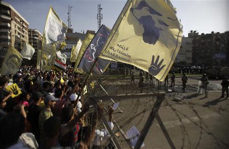 Members of the Muslim Brotherhood and supporters of ousted Egyptian President Mohamed Mursi shout slogans next to barbed wire as army soldiers and the riot police look on, during a protest against the military, near Rabaa al-Adaweya square in Cairo October 4, 2013. REUTERS/Amr Abdallah Dalsh