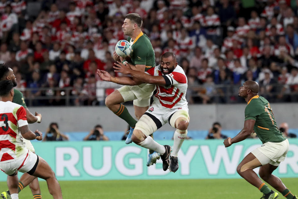 FILE - South Africa's Handre Pollard, center left, and Japan's Michael Leitch vie for the ball during the Rugby World Cup quarterfinal match at Tokyo Stadium in Tokyo, Japan, on Oct. 20, 2019. Japan has been a fan favorite at the last two Rugby World Cups for its underdog victories over top-tier teams. (AP Photo/Eugene Hoshiko, File)